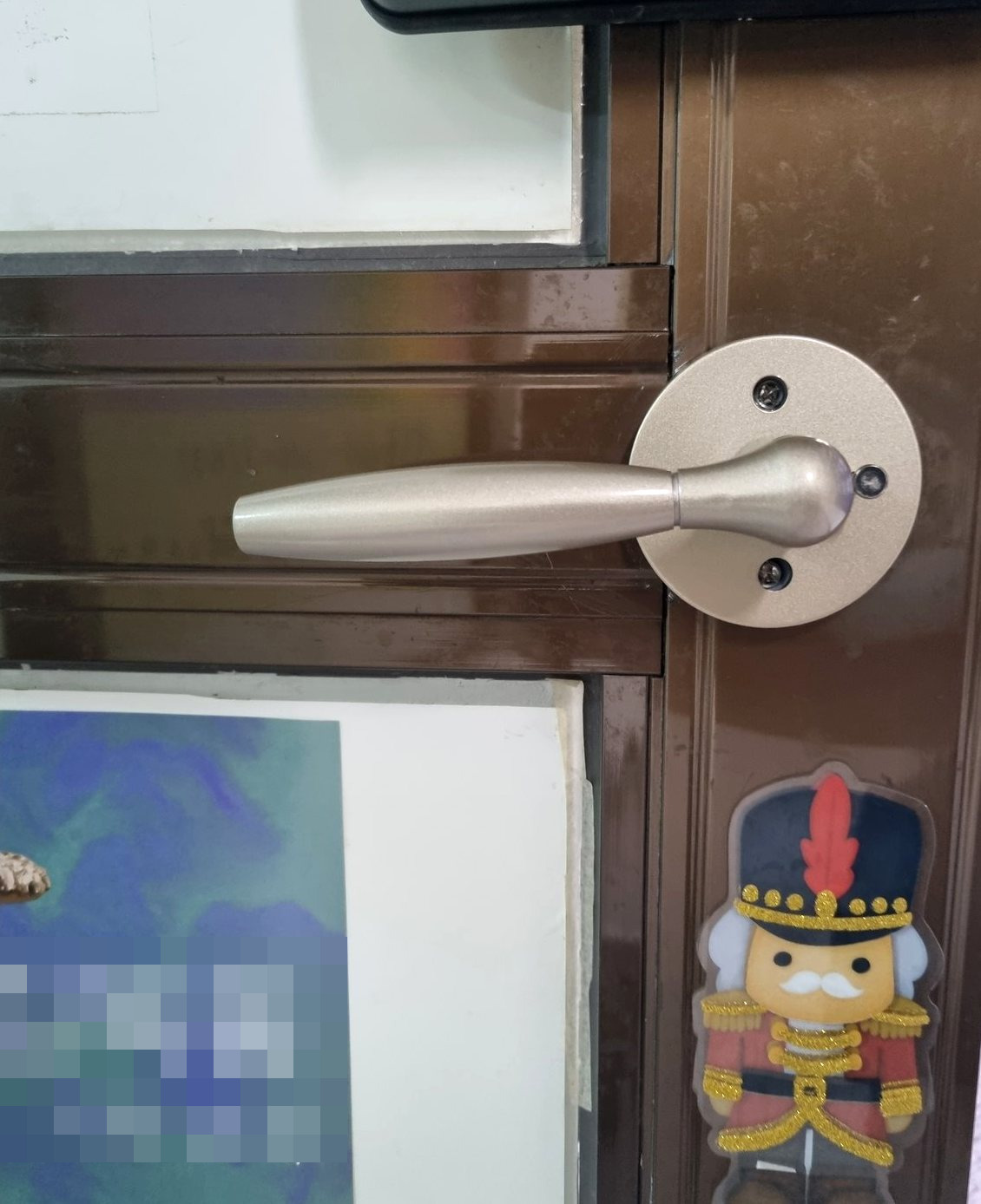 영종구 영종1동 출장 — 갈색 알루미늄 문에 달린 샴페인빛 레버 손잡이와 나사 세 개가 보이는 둥근 받침